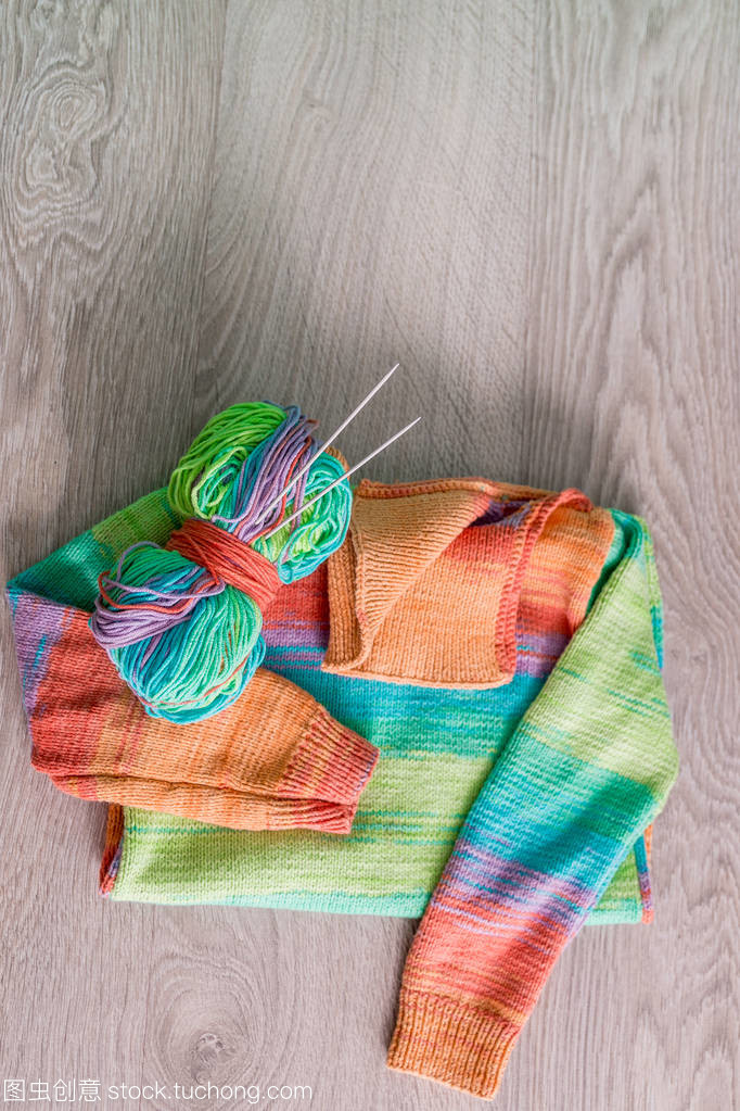 針織。針織毛衫。多色球的紗線用針附近上木制的灰色背景的手工產品。頂視圖。復制空間